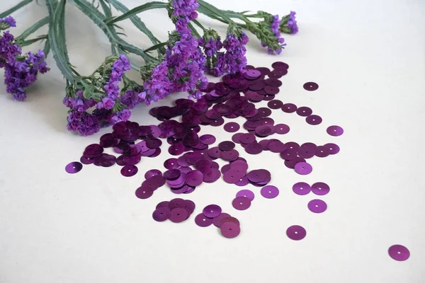 Detail of purple round sequins and purple dried flowers. — Stock Photo, Image