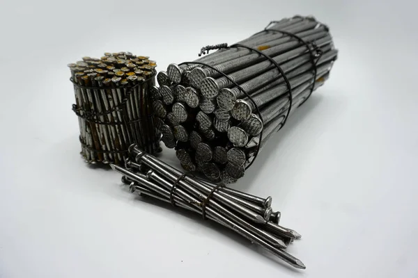 Byggspikar av stål i olika längder sammanbundna i grupper. — Stockfoto