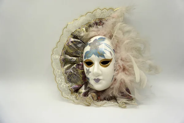 Vintage female porcelain venetian mask with delicate feathers and painted decorations. Stock Photo