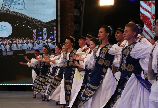 Timisoara, Rumunsko- 07.04.2019 Tanečníci se drží za ruce v tradičním rumunském folklórním tanci v tradičních krásných kostýmech na festivalu zdarma v parku. — Stock fotografie