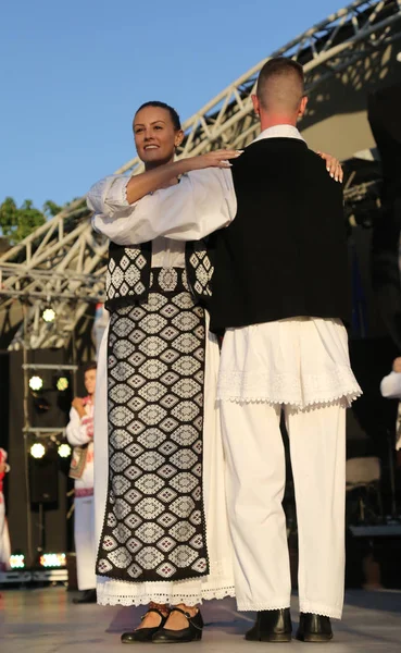 TIMISOARA, ROMANIE 07.04.2019 Les danseurs se tiennent la main dans une danse folklorique roumaine traditionnelle portant de beaux costumes traditionnels lors d'un festival gratuit dans le parc . — Photo