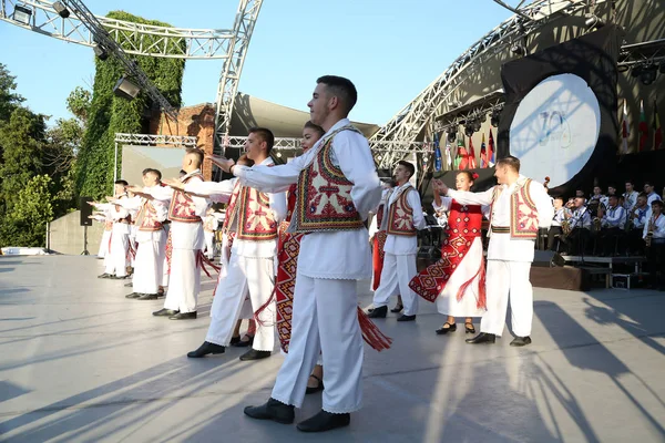 Timisoara, Rumunsko- 07.04.2019 Tanečníci se drží za ruce v tradičním rumunském folklórním tanci v tradičních krásných kostýmech na festivalu zdarma v parku. — Stock fotografie