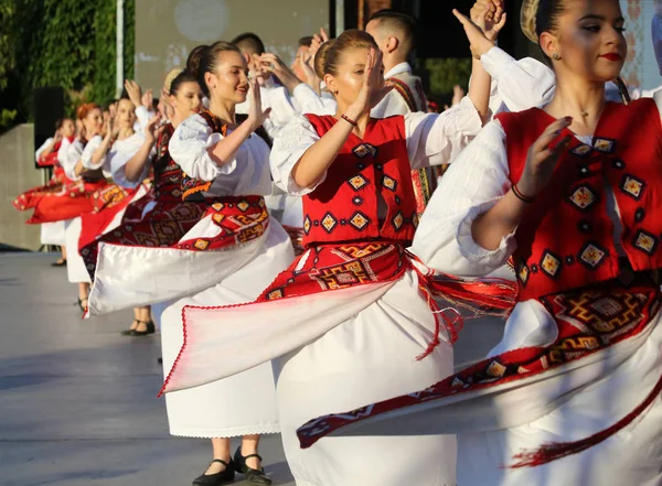 Timisoara, Rumänien- 07.04.2019 Dansare håller varandra i en traditionell rumänsk folkdans i traditionella vackra kostymer på en gratis festival i parken. Royaltyfria Stockbilder