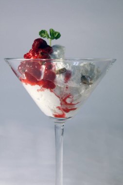 Delicious ice cream with forest fruit and mint leaves.