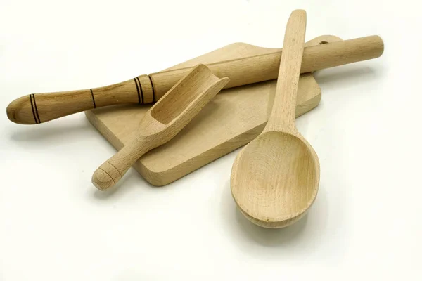 Drewniane naczynia kuchenne na białym tle. Deska do krojenia, łyżka i miarka. — Zdjęcie stockowe