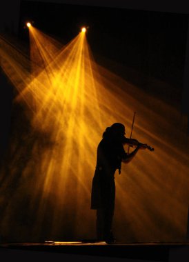 Sahnenin spot ışıklarındaki kemancı. Konserde kemancı,
