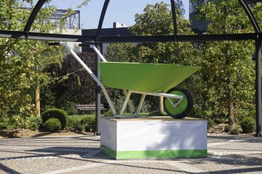 Büyük yeşil, yeni ve boş el arabası kullanımı bir platformda sergilenen bahçe ya da inşaat için. Bahçıvanlık veya inşaat aracı .