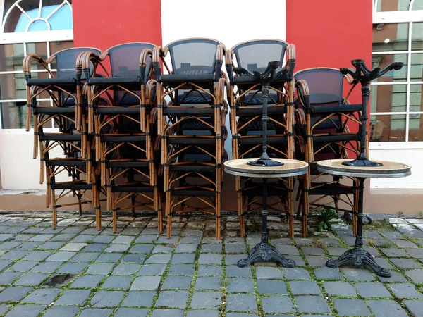 Chaises empilées d'un restaurant extérieur fermé . Photo De Stock