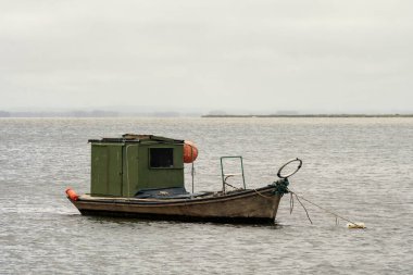old green fishing boat with orange floats