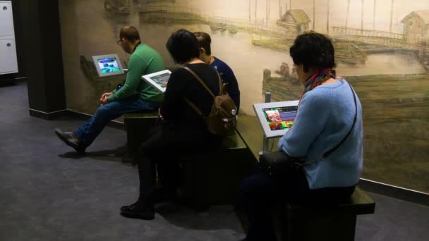 Люди смотрят в планшет в музее — стоковое видео