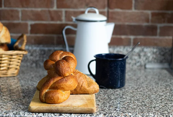 Tahtada kıvırcık ekmek ve bir fincan kahve.