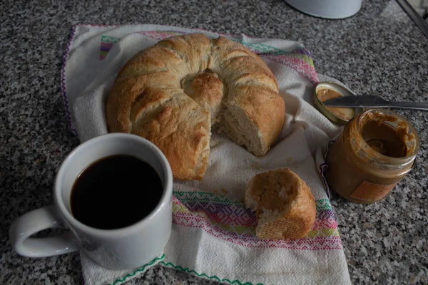 yuvarlak ekmek, kahve ve fıstık ezmesi.