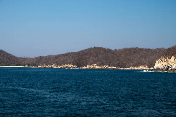 Huatulco Körfezi 'ndeki mavi okyanus ve kaya oluşumları