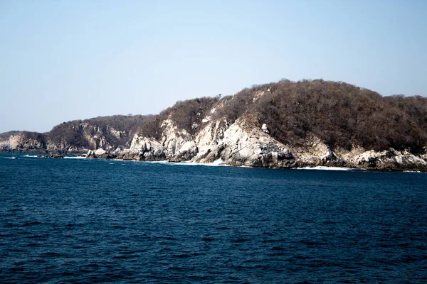 Huatulco Körfezi 'ndeki mavi okyanus ve kaya oluşumları