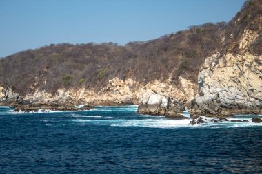 Huatulco Körfezi 'ndeki mavi okyanus ve kaya oluşumları
