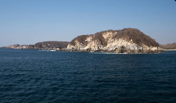 Huatulco Körfezi 'ndeki mavi okyanus ve kaya oluşumları