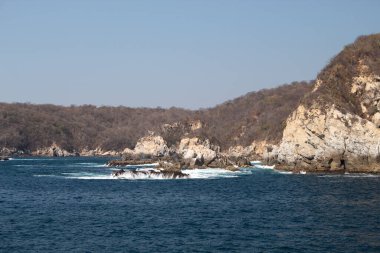 Huatulco Körfezi 'ndeki mavi okyanus ve kaya oluşumları