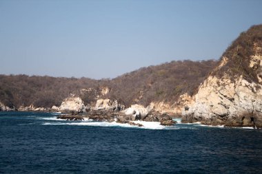 Huatulco Körfezi 'ndeki mavi okyanus ve kaya oluşumları