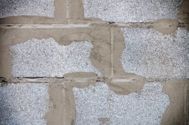  Beton harçla tutturulmuş taş bloklardan bir duvar.