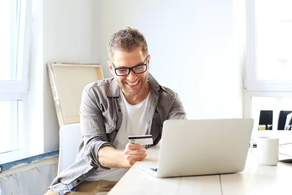 Young man pays for a purchase in an online store