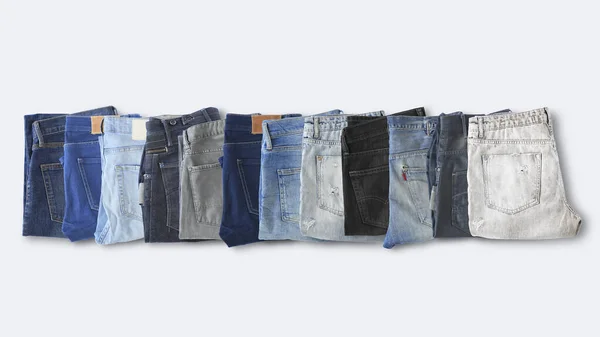Verschiedene Jeans Liegen Auf Dem Hellen Boden — Stockfoto