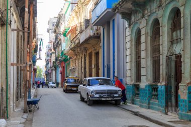 Havana 'nın merkezinde dar bir caddenin manzarası. Arabalar ve insanlarla dolu.