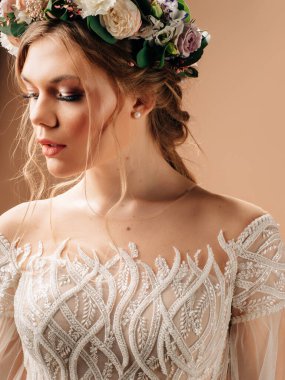 Çiçekli bir çiçek buketi içinde güzel bir gelin. Stüdyoda şeftali arkaplanlı yakın plan portre. 