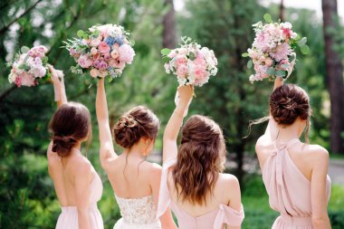 Summer wedding. Bridesmaids in pink dresses and bride holding beautiful bouquets. Beautiful luxury wedding blog concept. clipart