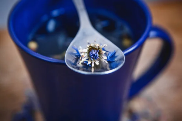 Coupe bleue et cuillère avec thé noir fleuri sur un fond en bois. Petit déjeuner, santé, phytothérapie, aliments sains. Concept et composition — Photo
