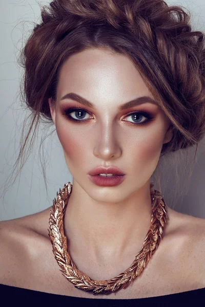 Beautiful girl with the Golden makeup and golden jewelry. Fashion woman Portrait