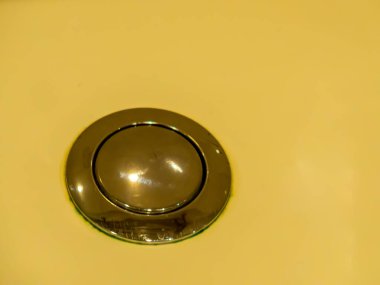 Arkasında gümüş rengi floş düğmesi, krem rengi.