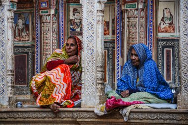 Nawalgarh, India - Dec 28, 2019: Women in traditional sari in front of a haveli