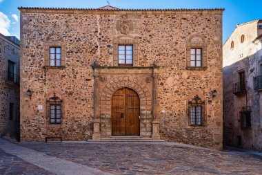 İspanya, Extremadura, Caceres 'deki Piskoposluk Sarayı. Santa Maria Meydanı 'nda, ana cephe, Rönesans tarzı, çift sıra küllerle süslenmiş yarım nokta kemerli dubası var.