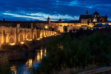 Cordoba, İspanya - 30 Ekim 2019: Mezquita-Katedral ve Puente Romano - Cami-Katedral ve gece İspanya 'nın Endülüs kentindeki Roma Köprüsü