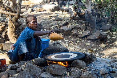 Tis Issat, Etiyopya - Şubat 05, 2020: Portekiz Köprüsü yakınlarında Mavi Nil nehri üzerinde ekmek pişiren Etiyopyalı kadın. Etiyopya.