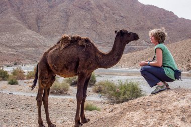 Erfoud, Fas - 17 Ekim 2019: Afrika, Fas 'ta Orta Çölü ve Erfoud arasında Sahra Çölü' nde bir turist kıza sarılan bir kız