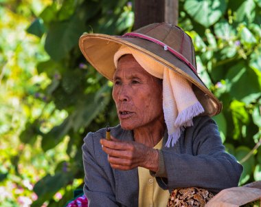 Heho, Myanmar - 08 Kasım 2019: Myanmar 'ın Heho kentindeki bir pazarda sigara içen kadın, Asya' nın eski Burma 'sı