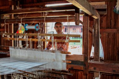 Inle Lake, Myanmar - 09 Kasım 2019: Padaung kabilesinin kadını, Karen uzun boyunlu kabile atkısı örüyor