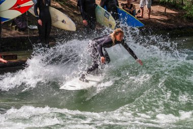 Münih, Almanya - 13 Temmuz 2019: Münih şehir nehrinde sörfçü, Eisbach adı verilen kentsel çevrede sörf yapan insanlarla ünlüdür.