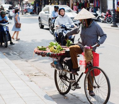 Vietnamca sokak satıcıları hareket ve kendi sebze ve meyve ürünleri Hanoi, Vietnam için satmak 