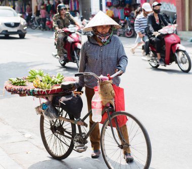Vietnamca sokak satıcıları hareket ve kendi sebze ve meyve ürünleri Hanoi, Vietnam için satmak 
