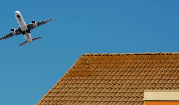 Airplane on departure over a residential area — Stock Photo, Image