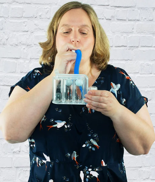 Femme fait des exercices de respiration avec un système d'entraînement pulmonaire 3 chambres — Photo