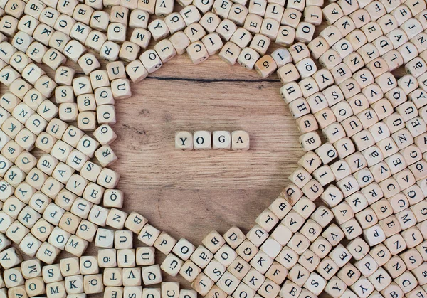 Yoga, German text for Yoga, word in letters on cube dices on table