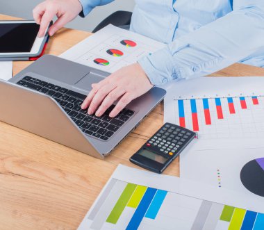 Onun iş konusunda uzman. Kadın defter ve onun işyerinde grafikleri bakarak bazı notlar yapma