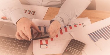 Onun iş konusunda uzman. Kadın defter ve onun işyerinde grafikleri bakarak bazı notlar yapma