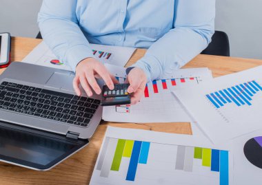 Onun iş konusunda uzman. Kadın defter ve onun işyerinde grafikleri bakarak bazı notlar yapma