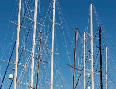 Türkiye 'nin Bodrum limanındaki gemi sütunları bulutsuz gökyüzünün önünde