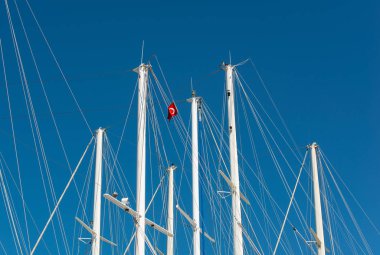 Türkiye 'nin Bodrum limanında bulutsuz gökyüzünün önünde gemi direği