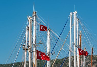 Türkiye 'nin Bodrum limanında bulutsuz gökyüzünün önünde gemi direği